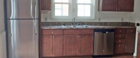 Kitchen with wood cabinets, wood-style floor and stainless steel appliances