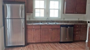 Kitchen with wood cabinets, wood-style floor and stainless steel appliances