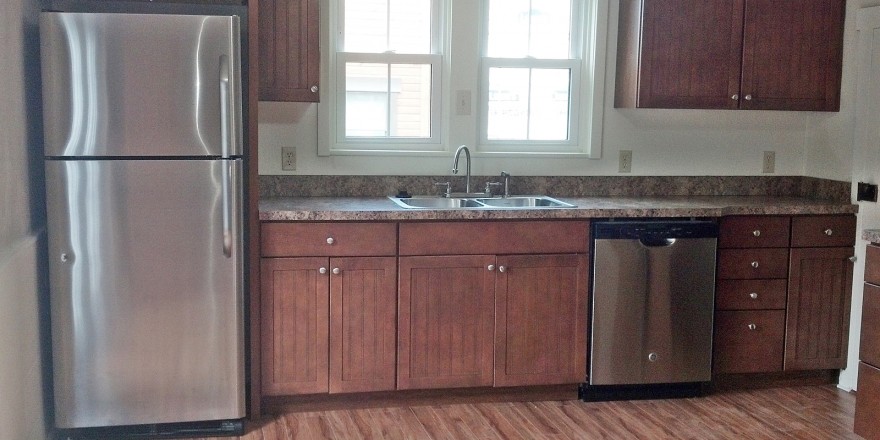 Kitchen with wood cabinets, wood-style floor and stainless steel appliances