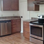 Kitchen with wood cabinets, wood-style floor and stainless steel appliances