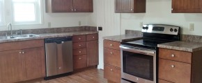 Kitchen with wood cabinets, wood-style floor and stainless steel appliances