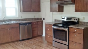 Kitchen with wood cabinets, wood-style floor and stainless steel appliances