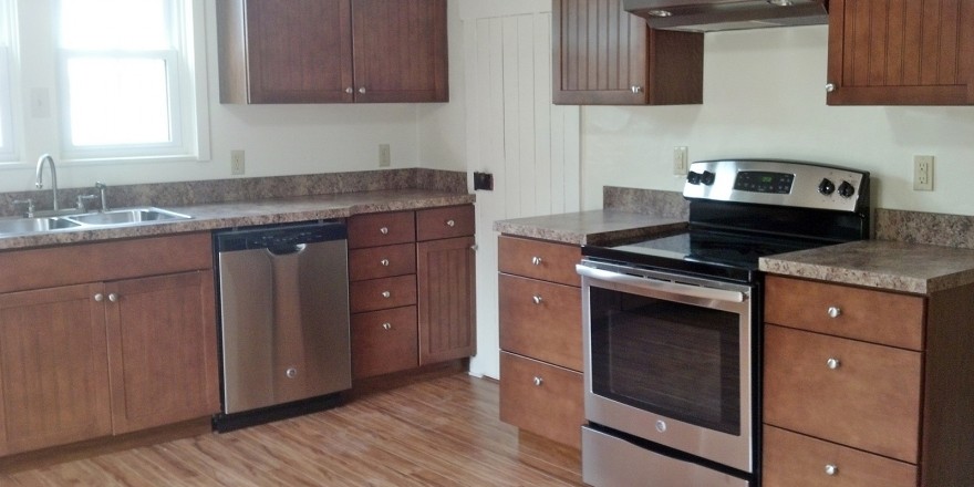 Kitchen with wood cabinets, wood-style floor and stainless steel appliances