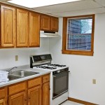 Kitchen with wooden cabinets and white appliances.