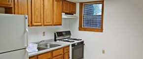 Kitchen with wooden cabinets and white appliances.