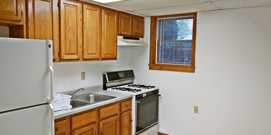 Kitchen with wooden cabinets and white appliances.