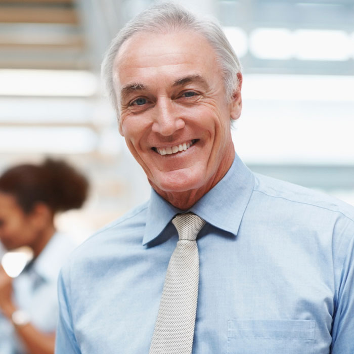 a smiling man in a blue shirt and tie