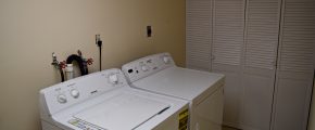 Laundry room with side-by-side top load washer and front load dryer and a closet