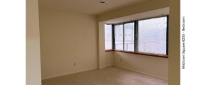 Unfurnished, carpeted bedroom with large windows