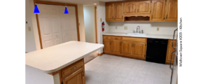 Kitchen with white and black appliances, tile flooring, wood cabinets, and large island