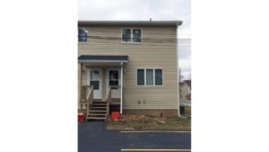 Exterior of duplex with tan siding and covered front entry