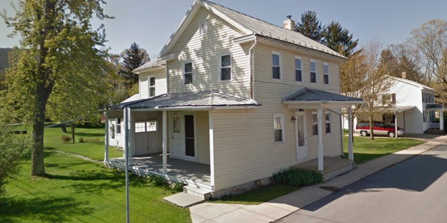 Exterior of house with yellow siding and, covered entry, and covered side porch