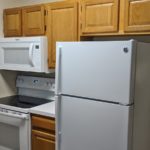 Kitchen with fridge, washing machine and microwave