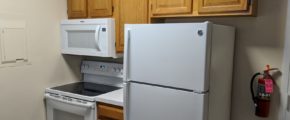 Kitchen with fridge, washing machine and microwave