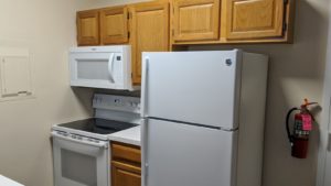 Kitchen with fridge, washing machine and microwave