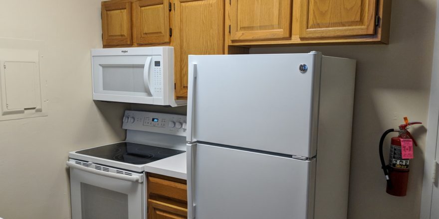 Kitchen with fridge, washing machine and microwave
