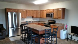 Open concept kitchen with wood-tone cabinets, island with barstool seating and stainless steel appliances