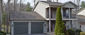 Exterior of two story house with large covered front porch, large balcony off the master bedroom, and large two car garage.