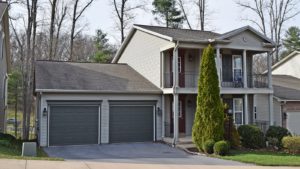 Exterior of two story house with large covered front porch, large balcony off the master bedroom, and large two car garage.