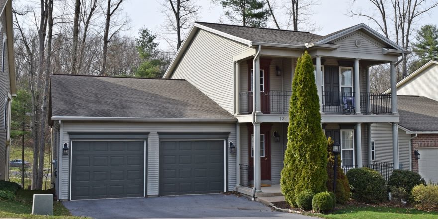 Exterior of two story house with large covered front porch, large balcony off the master bedroom, and large two car garage.