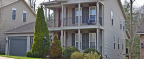 Exterior of two story house with large covered front porch, large balcony off the master bedroom, and large two car garage.