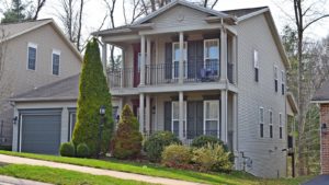 Exterior of two story house with large covered front porch, large balcony off the master bedroom, and large two car garage.