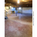 Unfinished basement with large wash tub, and side-by-side washer and dryer