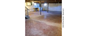 Unfinished basement with large wash tub, and side-by-side washer and dryer