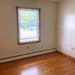 Unfurnished bedroom with hardwood floors and window