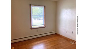 Unfurnished bedroom with hardwood floors and window
