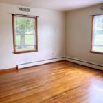 Unfurnished bedroom with hardwood floors and windows