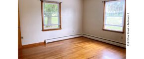 Unfurnished bedroom with hardwood floors and windows