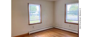 Unfurnished bedroom with hardwood floors and windows