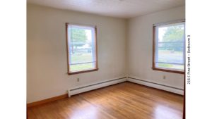 Unfurnished bedroom with hardwood floors and windows