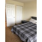 Carpeted bedroom with large bed