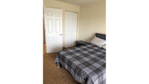 Carpeted bedroom with large bed