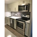 Kitchen with white cabinets, stainless steel appliances, and backsplash