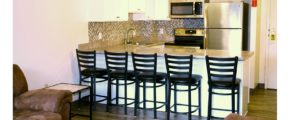 Kitchen with white cabinets, stainless steel appliances, sink, and barstool seating