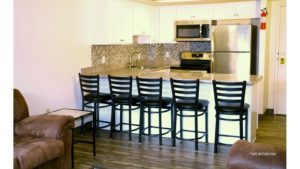 Kitchen with white cabinets, stainless steel appliances, sink, and barstool seating