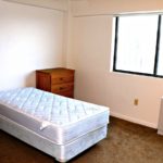 Bedroom with twin bed and wooden furniture