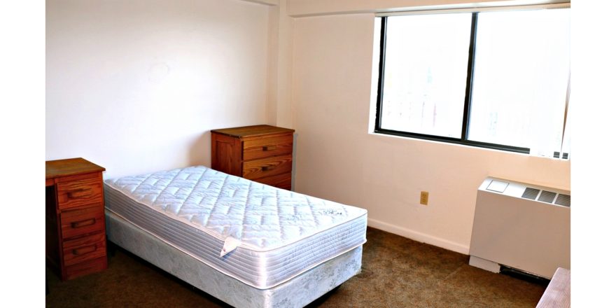 Bedroom with twin bed and wooden furniture