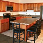 Kitchen with wood-tone cabinets, island with barstool seating, and stainless steel appliances
