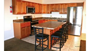 Kitchen with wood-tone cabinets, island with barstool seating, and stainless steel appliances