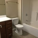 Bathroom with shower/tub combo, toilet, and vanity and mirror