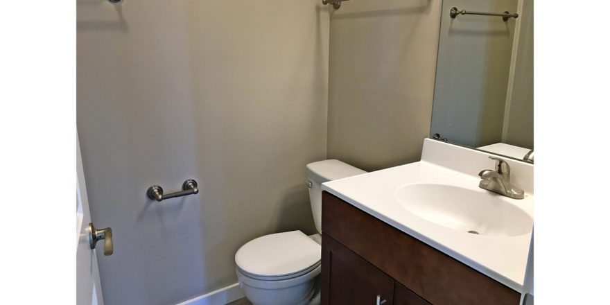 Bathroom with mirror, vanity and toilet.