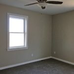 Carpeted, unfurnished bedroom with two windows