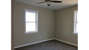 Carpeted, unfurnished bedroom with two windows