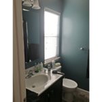 Bathroom with vanity, mirror, toilet and window
