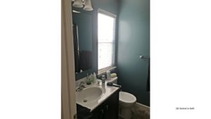Bathroom with vanity, mirror, toilet and window