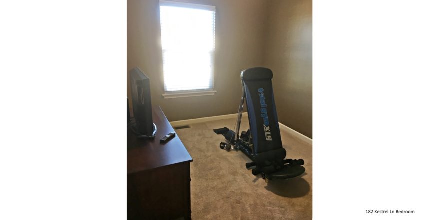 Carpeted bedroom with window, tv, tv stand exercise equipment